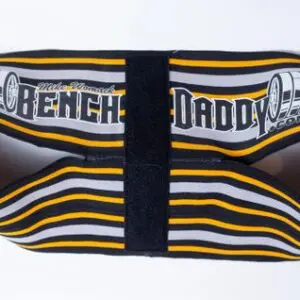 A weightlifting belt labeled 'Bench Daddy' with black, yellow, and white stripes.